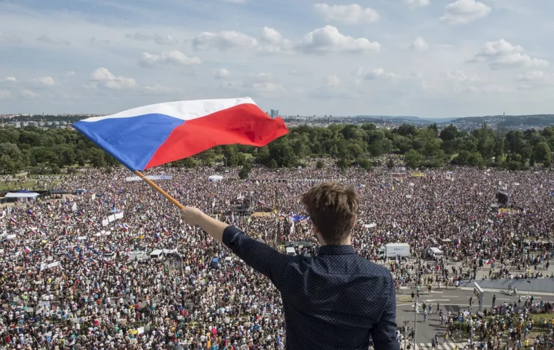 A man holds a Czech National flag during a rally demanding the resignation of Czech Prime Minister Andrej Babis on June 23, 2019 in Prague. - Huge crowds flooded central Prague demanding Prime Minister Andrej Babis to step down over allegations of graft in a protest that organisers and local media claim drew around 250,000 people, which would make it the largest since the fall of communism in 1989. (Photo by Michal Cizek / AFP)