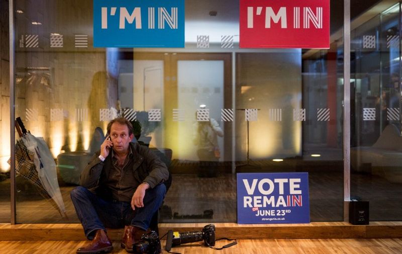 A press photographer talks on a phone as supporters of the Stronger In Campaign gather to wait for the result of the EU referendum at a results party at the Royal Festival Hall in London early in the morning of June 24, 2016.
The first mainland result declared in Britain's historic EU referendum on Thursday gave a very slender lead to the campaign to stay in the bloc, but was much closer than expected, an expert said. / AFP PHOTO / POOL / ROB STOTHARD