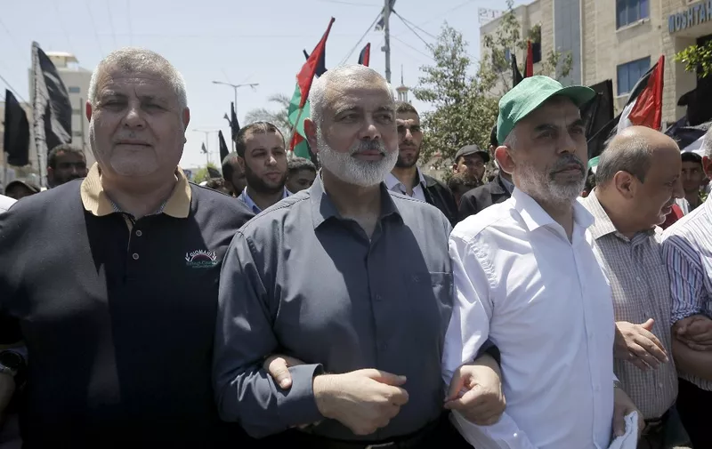 Hamas leaders in the Gaza Strip Ismail Haniya (C) and Yahya Sinwar (R) walk alongside   Islamic Jihad's Khaled al-Batch (L) in Gaza City on June 26, 2019  during a protest against a US-sponsored Middle East economic conference in Bahrain. (Photo by MOHAMMED ABED / AFP)