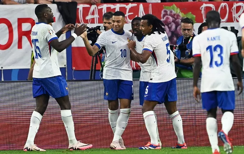 France's forward #10 Kylian Mbappe celebrates with France's defender #05 Jules Kounde (R) and France's forward #15 Marcus Thuram (L) the team's first goal during the UEFA Euro 2024 Group D football match between Austria and France at the Duesseldorf Arena in Duesseldorf on June 17, 2024. (Photo by OZAN KOSE / AFP)