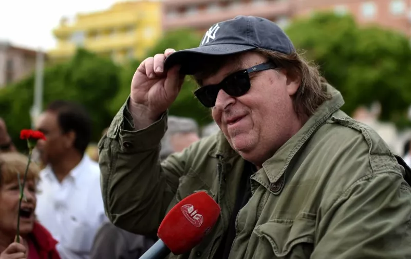 US film director Michael Moore is interviewed as he takes part in a May Day demonstration at Alameda in Lisbon on May 1, 2015. Tens of thousands of people across the globe were hitting the streets on May 1 for mass rallies marking International Labour Day. AFP PHOTO/ FRANCISCO LEONG