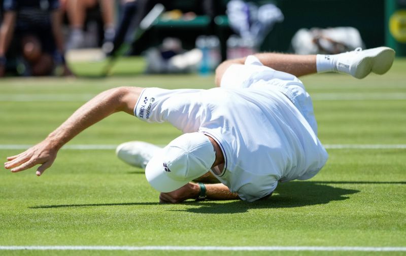 Hubert Hurkacz of Poland falls attempting to return a shot to Arthur Fils of France during their second round match at the Wimbledon tennis championships in London, Thursday, July 4, 2024. (AP Photo/Mosa'ab Elshamy)