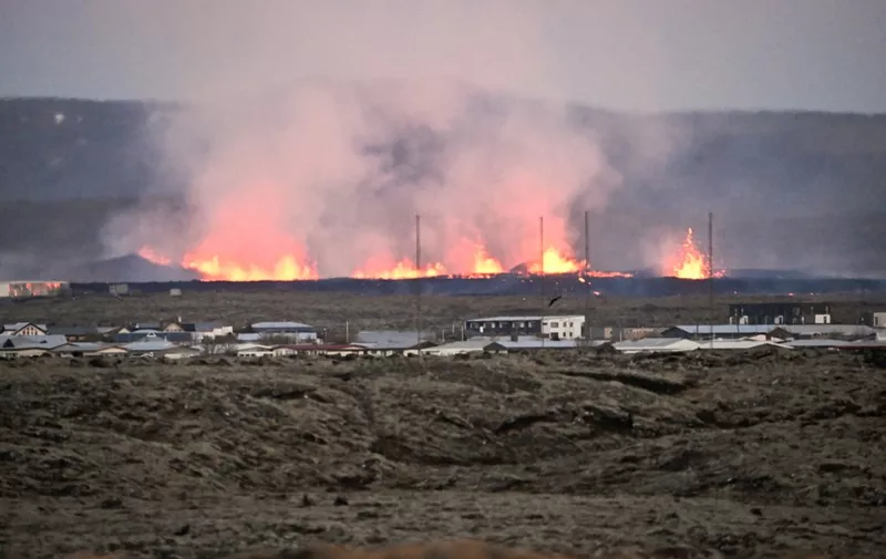 Lava explosions and billowing smoke are seen near residential buildings in the southwestern Icelandic town of Grindavik after a volcanic eruption on January 14, 2024. Seismic activity had intensified overnight and residents of Grindavik were evacuated, Icelandic public broadcaster RUV reported. This is Iceland's fifth volcanic eruption in two years, the previous one occurring on December 18, 2023 in the same region southwest of the capital Reykjavik. Iceland is home to 33 active volcano systems, the highest number in Europe. (Photo by Halldor KOLBEINS / AFP)