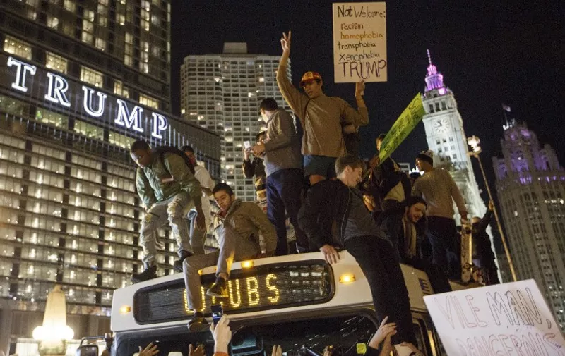 CHICAGO, IL - NOVEMBER 09: Demostrators protest on top of a bus outside of the Trump Tower November 9, 2016 in Chicago, Illinois. Thousands of people in several cities across the country took to the streets a day after Donald Trump was elected president.   John Gress/Getty Images/AFP