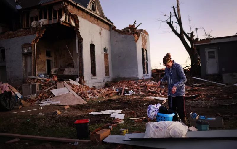 MAYFIELD, KENTUCKY - DECEMBER 12: Jessica Hart salvages items from a home that was destroyed after being hit by a tornado late Friday evening on December 12, 2021 in Mayfield, Kentucky. Multiple tornadoes touched down in several Midwest states late evening December 10 causing widespread destruction and leaving more than 80 people dead.   Scott Olson/Getty Images/AFP (Photo by SCOTT OLSON / GETTY IMAGES NORTH AMERICA / Getty Images via AFP)