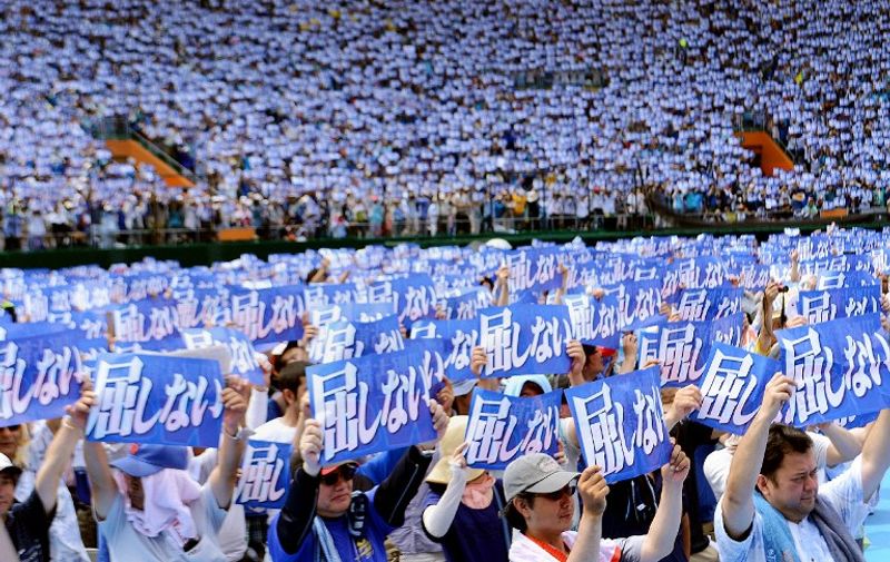 Some 35,000 protesters raise placards saying "Do not yield to authority" during a rally to protest against a controversial US airbase in Naha in Japan's southern island of Okinawa on May 17, 2015. Futenma US airbase has become emblematic of that ill-will since Washington announced plans to move it in 1996, hoping to ease tensions with the host community after the gang-rape of a schoolgirl by servicemen. But locals have blocked the move to relocate the base, insisting the facility should go off-island instead, harming relations between Tokyo and Okinawa -- a once independent kingdom that was annexed by Japan in the 19th century.      JAPAN OUT   --  AFP PHOTO / JIJI PRESS