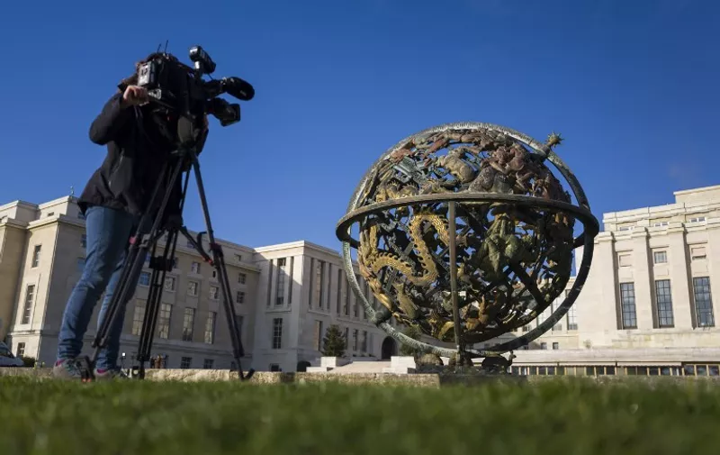 A camerawoman films the Globe outside of the United Nations (UN) Offices on the opening day of Syrian peace talks on January 29, 2016 in Geneva. 
UN-mediated peace talks aimed at ending Syria's conflict are scheduled to kick off on January 29, 2016, but the absence of key opposition members threatens to derail the biggest diplomatic push yet to resolve the nearly five-year-old civil war. / AFP / FABRICE COFFRINI