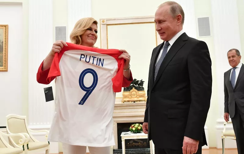 Croatian President Kolinda Grabar-Kitarovic (L) offers to Russian President Vladimir Putin a jersey of the Croatian national football team bearing the name Putin, ahead of the Russia 2018 World Cup final football match between France and Croatia, during their meeting at the Kremlin in Moscow on July 15, 2018. (Photo by Yuri KADOBNOV / POOL / AFP)