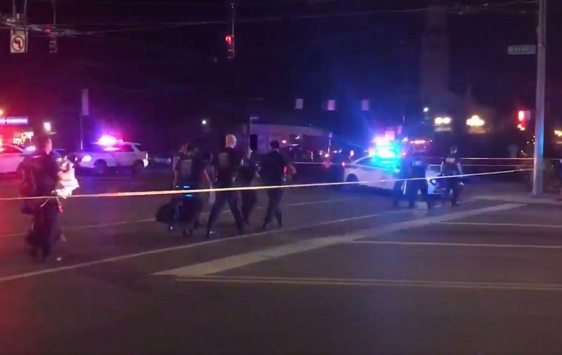 This videograb taken from the Twitter account of Derek Myers on August 4, 2019 shows police officers walking behind police cordon following a mass shooting in the popular bar and nightlife Oregon district in Dayton, Ohio. - Nine people were killed in a mass shooting early on August 4 in Dayton, Ohio, police said, adding that the assailant was shot dead by responding officers. (Photo by Derek MYERS / @DerekMyers Twitter account / AFP)