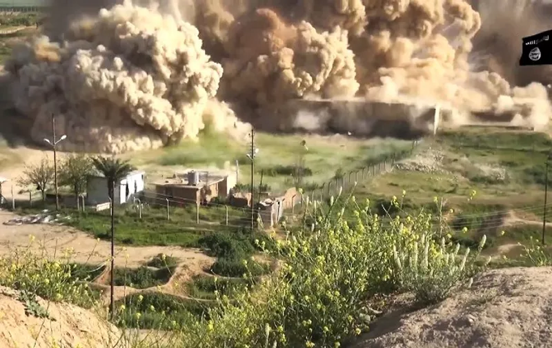 An image grab taken from a video made available by Jihadist media outlet Welayat Nineveh on April 11, 2015, allegedly shows smoke billowing from an ancient site after it was wired with explosives by Islamic State (IS) militant group in northern Iraq. The Islamic State group released an undated video in which militants smash artefacts in what they said was the ancient Assyrian city of Nimrud  before blowing it up. The undated video suggests more than a month after destruction on the spot was reported  that the site, which is located on the Tigris about 30 kilometres (18 miles) southeast of Mosul, was completely levelled. AFP PHOTO / HO / WELAYAT NINEVEH
=== RESTRICTED TO EDITORIAL USE - MANDATORY CREDIT "AFP PHOTO / HO / WELAYAT NINEVEH" - NO MARKETING NO ADVERTISING CAMPAIGNS - DISTRIBUTED AS A SERVICE TO CLIENTS FROM ALTERNATIVE SOURCES, AFP IS NOT RESPONSIBLE FOR ANY DIGITAL ALTERATIONS TO THE PICTURE'S EDITORIAL CONTENT, DATE AND LOCATION WHICH CANNOT BE INDEPENDENTLY VERIFIED ===