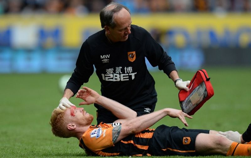 Hull City's Irish defender Paul McShane receives medical treatment to a head injury and a leg injury after a challenge from Manchester United's Belgian midfielder Marouane Fellaini after which Fellaini was sent off during the English Premier League football match between Hull City and Manchester United at the KC Stadium in Kingston upon Hull, north east England on May 24, 2015.  AFP PHOTO / OLI SCARFF

RESTRICTED TO EDITORIAL USE. NO USE WITH UNAUTHORIZED AUDIO, VIDEO, DATA, FIXTURE LISTS, CLUB/LEAGUE LOGOS OR LIVE SERVICES. ONLINE IN-MATCH USE LIMITED TO 45 IMAGES, NO VIDEO EMULATION. NO USE IN BETTING, GAMES OR SINGLE CLUB/LEAGUE/PLAYER PUBLICATIONS.
