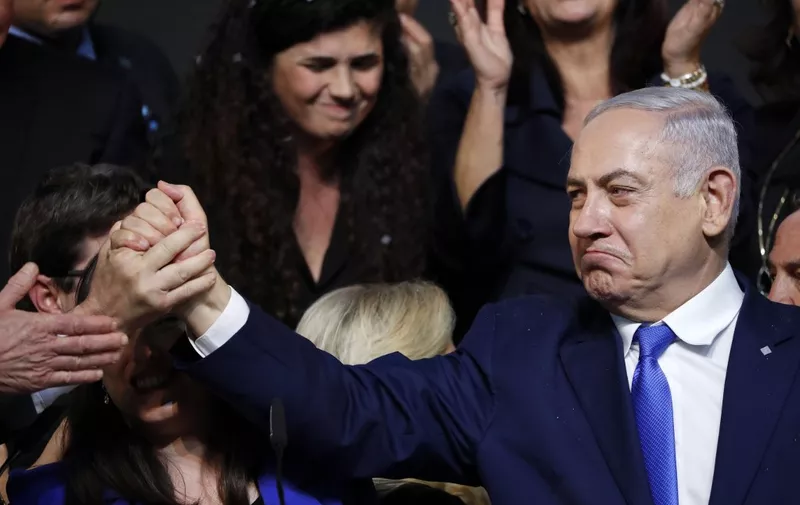 Israeli Prime Minister Benjamin Netanyahu reacts as he shakes hands with someone after addressing supporters at his Likud Party headquarters in the Israeli coastal city of Tel Aviv on election night early on April 10, 2019. (Photo by Thomas COEX / AFP)