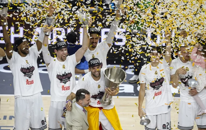 Spain's King Felipe VI (DOWN) congratulates Real Madrid's forward Felipe Reyes (C) and players after they won the Euroleague Final Four basketball final against Olympiacos Pireus at the Palacio de los Deportes in Madrid on May 17, 2015.    AFP PHOTO / DANI POZO