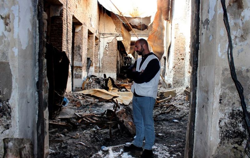 In this photograph taken on November 10 ,2015, a member of Medecins Sans Frontieres (MSF) staff looks on in a charred corridor of the damaged Medecins Sans Frontieres (MSF) hospital in northern Kunduz.  On October 3, 2015 US forces bombed the MSF Hospital in northern Kunduz, killing at least 30 people, sparking an avalanche of global condemnation and forcing the French-founded charity to close the trauma centre.  AFP PHOTO / Najim RAHIM / AFP / NAJIM RAHIM