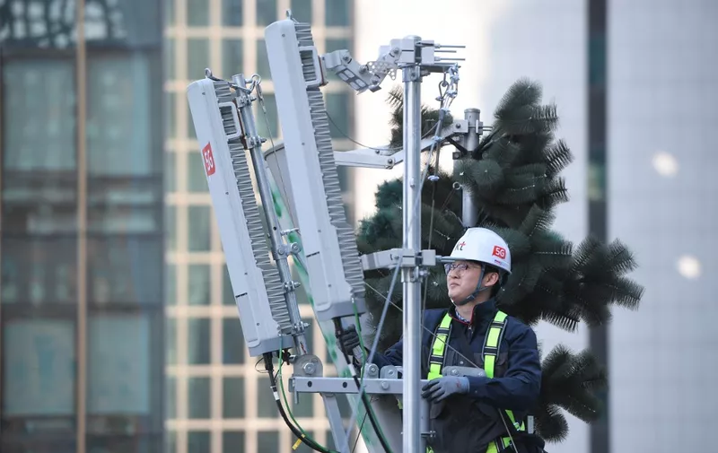 A technician of South Korean telecom operator KT checks an antenna for the 5G mobile network service on the rooftop of a building in Seoul on April 4, 2019. - South Korea launched the world's first nationwide 5G mobile networks two days early, its top mobile carriers said on April 4, giving a handful of users access in a late-night scramble to be the first providers of the super-fast wireless technology. (Photo by JUNG Yeon-Je / AFP)