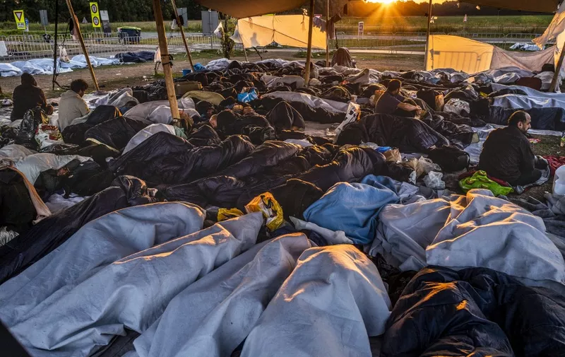 Hundreds of asylum seekers sleep outside the gate at the application center in Ter Apel, The Netherlands, 25 August 2022. - The Groningen application center has been busy for months. Asylum seekers' centers no longer have a place and status holders cannot move on to a home due to, among other things, the overheated housing market. (Photo by Vincent JANNINK / ANP / AFP) / Netherlands OUT