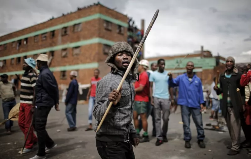 TOPSHOTS Zulu protesters demonstrate against foreign migrants outside their hostel in the Jeppestown district of Johannesburg on April 17, 2015. AFP PHOTO/MARCO LONGARI
