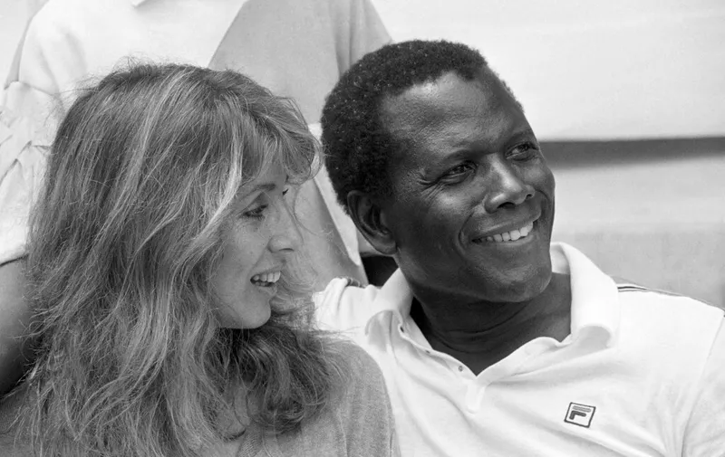 Photo taken on June 25, 1983 shows  Bahamian-American actor Sidney Poitier (R) and his wife Joanna Shimkus during the Monte-Carlo ATP Masters Series Tournament tennis match. (Photo by Ralph Gatti / AFP)