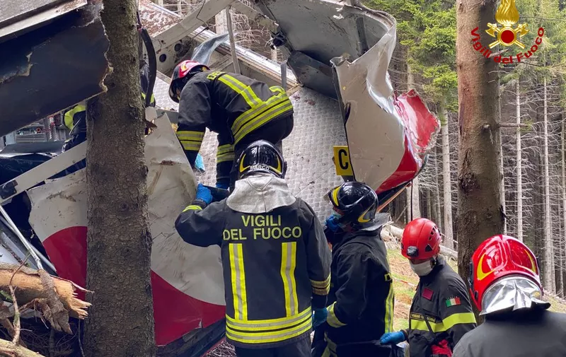 A photo taken on May 23, 2021 and handout on May 24, 2021 by The Italian Firefighters "Vigili del Fuoco" shows rescuers at work by a cable car that crashed to the ground in the resort town of Stresa on the shores of Lake Maggiore in the Piedmont region. - 14 people died on May 23 after a cable car crashed to the ground in northern Italy, emergency services said. (Photo by Handout / Vigili del Fuoco / AFP) / RESTRICTED TO EDITORIAL USE - MANDATORY CREDIT "AFP PHOTO / VIGILI DEL FUOCO / HANDOUT " - NO MARKETING - NO ADVERTISING CAMPAIGNS - DISTRIBUTED AS A SERVICE TO CLIENTS