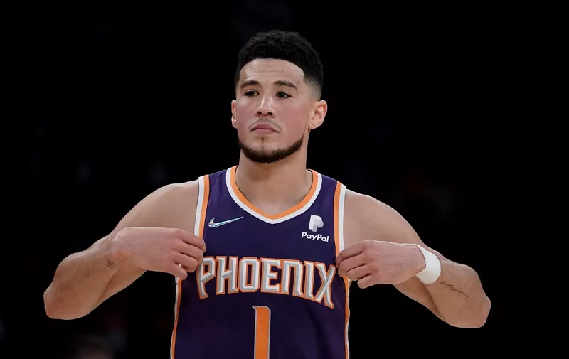 Phoenix Suns' Devin Booker walks on the court during first half of an NBA basketball game against the Los Angeles Lakers Tuesday, Dec. 21, 2021, in Los Angeles. (AP Photo/Jae C. Hong)