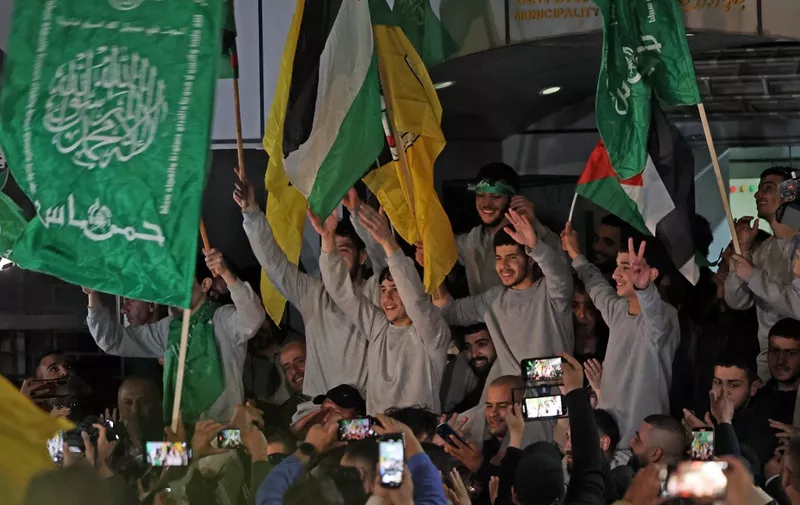 Palestinian prisoners (wearing grey jumpers) cheer after being released from the Israeli Ofer military facility in Baytunia near the city of Ramallah in the occupied West Bank in exchange for hostages freed by Hamas in Gaza, on November 24, 2023. After 48 days of gunfire and bombardment that claimed thousands of lives, the first hostages to be released under a truce deal between Israel and Hamas were handed over on November 24, both sides said, nearly seven weeks after they were seized. (Photo by AHMAD GHARABLI / AFP)