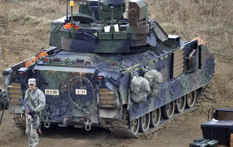 A US soldier stands behind a Bradley armored vehicle at a military training field in the border city of Yeoncheon, northeast of Seoul, on April 11, 2013.  The United States has warned North Korea it is skating a "dangerous line" with an expected missile launch that could start a whole new cycle of escalating tensions in a region already on a hair-trigger.  AFP PHOTO / JUNG YEON-JE (Photo by AFP)
