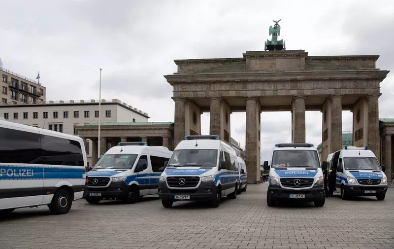 Police cars are seen in front of the landmark Brandenburg Gate during anti-lockdown protests in Berlin on August 1, 2021. - Berlin police clashed with Covid sceptics on August 1 after hundreds of them took to the streets despite a court-ordered protest ban over concerns participants would not respect rules on mask-wearing and social distancing. (Photo by Paul ZINKEN / AFP)
