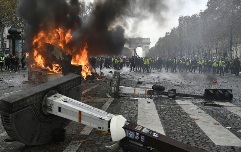 A truck burns during a protest of Yellow vests (Gilets jaunes) against rising oil prices and living costs near the Arc of Triomphe on the Champs Elysees in Paris, on November 24, 2018. - Police fired tear gas and water cannon on November 24 in central Paris against "yellow vest" protesters demanding French President Emmanuel Macron roll back tax hikes on motor fuel. (Photo by Bertrand GUAY / AFP)