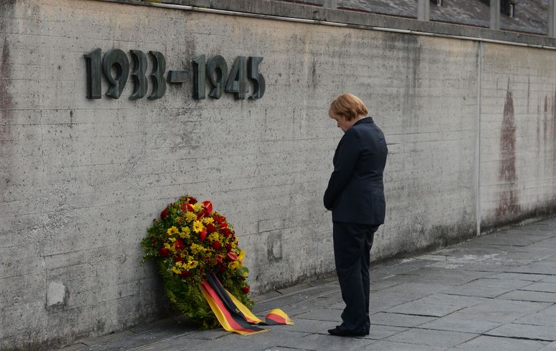 German Chancellor Angela Merkel attends a wreath laying ceremony during her visit to the concentration camp Dachau  where more than 43,000 persons were murdered and over 200,000 were imprisoned during the Nazis terror reign from 1933-1945 in Dachau, southern Germany, on Tuesday, Aug.20, 2013.  Merkel  was invited by a former inmate, 93-year-old Max Mannheimer, who was liberated from Dachau by American soldiers in 1945.   Merkels visit Tuesday evening was the first by a German chancellor to Dachau. (AP Photo/Kerstin Joensson)