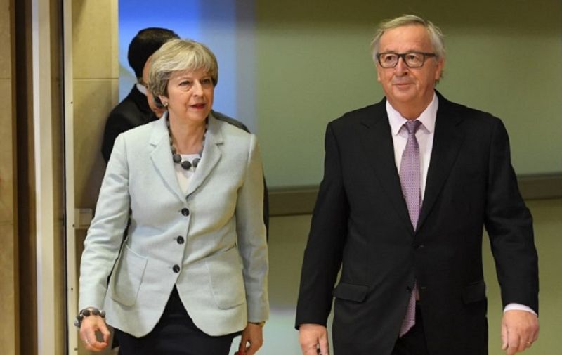 British Prime Minister Theresa May (L) is welcomed by European Commission Jean-Claude Juncker at European Commission in Brussels on December 8, 2017.  / AFP PHOTO / EMMANUEL DUNAND