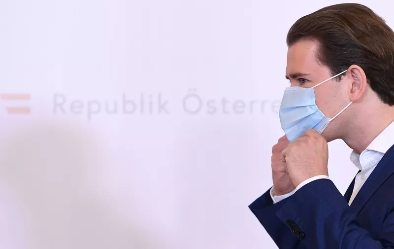 Sebastian Kurz, Austria's Chancellor and leader of Austria's People's party (OeVP), takes his face protection mask off as he arrives to give a press conference at the Chancellery in Vienna, amid the novel coronavirus / COVID-19 pandemic on May 25, 2020. (Photo by HELMUT FOHRINGER / APA / AFP) / Austria OUT