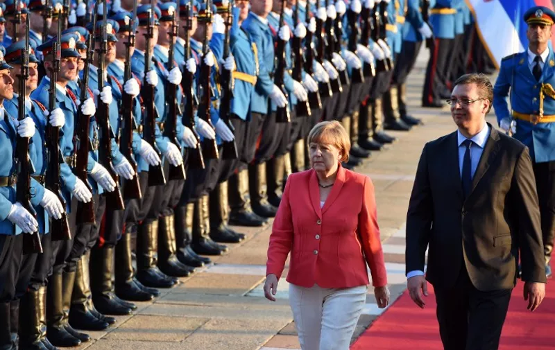German Chancellor Angela Merkel (2nd R) and Serbian Prime Minister Aleksandar Vucic (R) inspect a military guard of honour prior to their meeting in Belgrade, Serbia, on July 8, 2015. Angela Merkel is on a two-day visit to the Balkan States of Albania, Serbia and Bosnia, three countries whose ambitions to join the European Union have been complicated by the Greek crisis and their mutual rivalries.  AFP PHOTO / ANDREJ ISAKOVIC