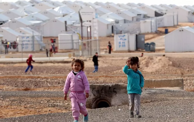 Young Syrian refugees stand at the Azraq refugee camp in northern Jordan on January 30, 2016. / AFP / KHALIL MAZRAAWI