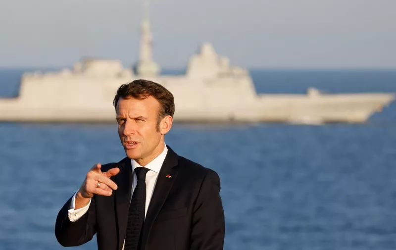 French President Emmanuel Macron gestures on the flight deck aboard the French aircraft carrier Charles de Gaulle, sailing between the Suez canal and the Red Sea on December 19, 2022. - French President Emmanuel Macron joined the French aircraft carrier Charles de Gaulle on December 19, 2022 for the traditional Christmas party with the troops, before attending a regional conference in Jordan on December 20, the Elysee presidential palace announced. (Photo by Ludovic MARIN / POOL / AFP)