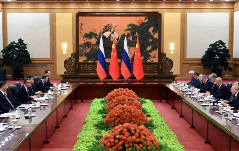 This pool photograph distributed by Russian state owned agency Sputnik shows Russia's President Vladimir Putin (R), Chinese President Xi Jinping (L) and members of the both delegations holding a meeting in Beijing on October 18, 2023. (Photo by Sergei GUNEYEV / POOL / AFP)