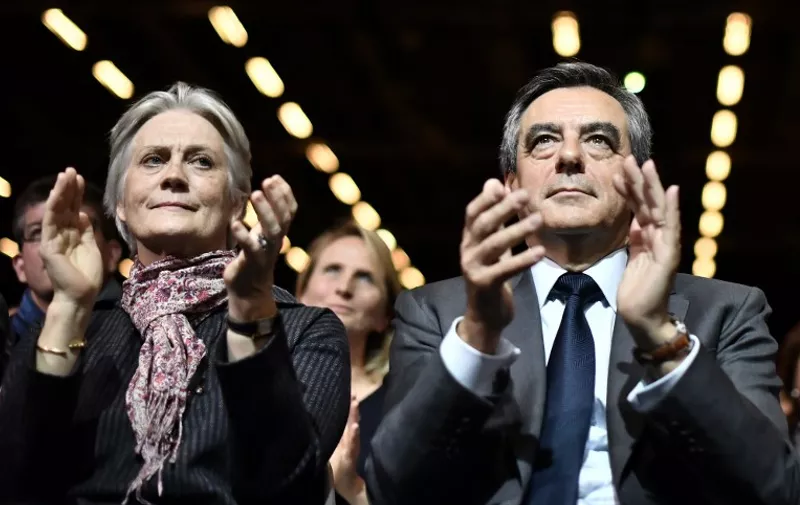 (FILES) This file photo taken on November 25, 2016 shows Francois Fillon (C), candidate for the right-wing primaries ahead of the French 2017 presidential election, and his wife Penelope (L) attending a campaign rally in Paris, ahead of the primary's second round on November 27.
The British-born wife of French presidential candidate Francois Fillon was paid around 500,000 euros ($538,000) over nearly a decade out of parliamentary funds, a satirical weekly reported on January 25, 2017. The Canard Enchaine, which mixes satire with investigative reporting, detailed various periods during which Penelope Fillon was paid from money available to her husband as a longstanding MP for the central Sarthe region.
 / AFP PHOTO / PHILIPPE LOPEZ