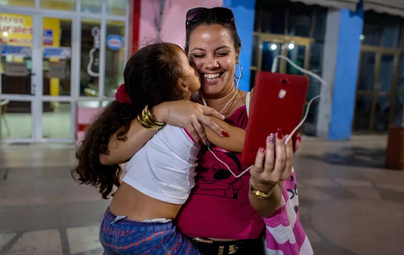 February 22, 2018 - Sancti Spiritus, Cuba: A woman chats live with a member of her family who lives abroad thanks to IMO, an instant video application, at parque Serafin Sanchez. Despite starting to 'open up' during the Obama years, Cuba remains largely isolated. Internet access is still controlled and limited. While the United States have announced the creation of a government commission to connect the island to the internet, causing serious tensions between the two countries, Cubans have to wait and adapt. Wifi is only accessible in certain places in big cities, and one gets access to it by buying expensive microchips. Every night, these areas fill up: families, young people, workers, alone or accompanied, come to connect to the internet, for a few minutes or hours. Many of them "Skype" with their family in the U.S., chat via IMO, others go on Facebook, or watch videos online. Sounds emanate from all of the small groups, concentrated on their screens, and indifferent to their neighbors. A strange sound is played, a happy cacophony.  Since his election last April, the Cuban head of state, Miguel Diaz-Canel, has promised that by 2020, 60 percent of households will be connected to the internet. In the meantime, system D prevails., Image: 391806521, License: Rights-managed, Restrictions: No publication in France, Model Release: no, Credit line: Profimedia, Polaris