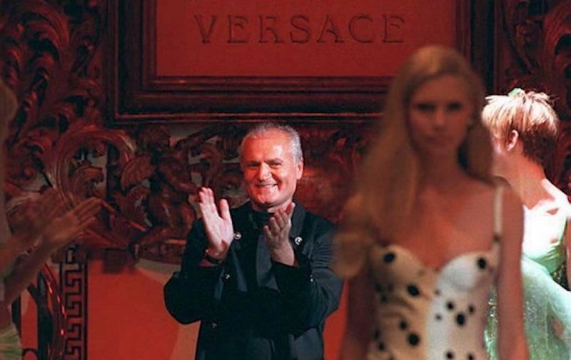 Italian designer Gianni Versace takes a bow after presenting his Atelier's 1995 "Couture-Style" collection in Paris 21 January. He called his vision for summer "something from inside which each individual can express according to his own personality, freely mixing precious High Fashion garments with different elements such as jeans or other fundamentals from our own wardrobes." (COLOR KEY: Red background.) AFP PHOTO / AFP PHOTO / PIERRE VERDY