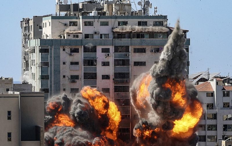 A ball of fire erupts from the Jala Tower as it is destroyed in an Israeli airstrike in Gaza City, controlled by the Palestinian Hamas movement, on May 15, 2021. - Israeli air strikes pounded the Gaza Strip, killing 10 members of an extended family and demolishing a key media building, while Palestinian militants launched rockets in return amid violence in the West Bank. Israel's air force targeted the 13-floor Jala Tower housing Qatar-based Al-Jazeera television and the Associated Press news agency. (Photo by Mahmud Hams / AFP)
