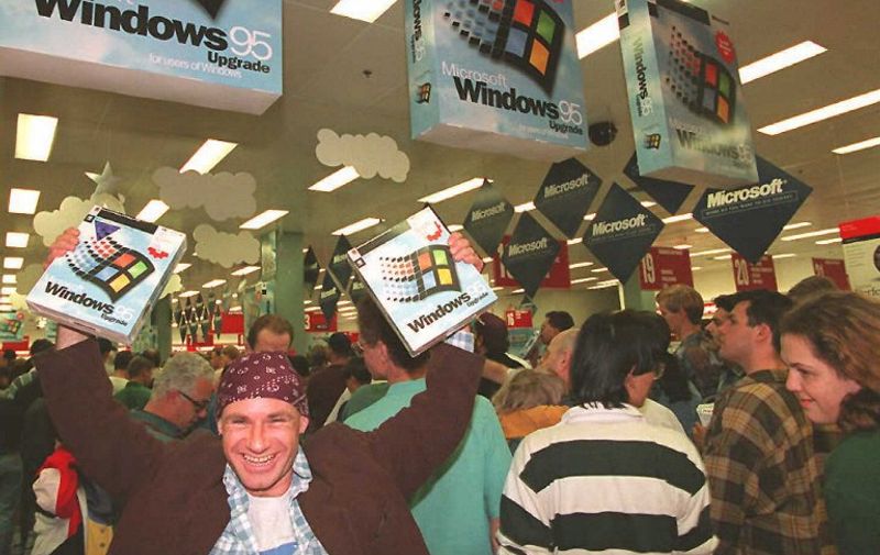Mikol Furneaux(L) waves two packages of Windows 95 software in the first store in Australia to sell the product at midnight 24 August.   Microsoft hopes to sell between 20 and 30 million copies of the software world wide by the end of 1995. AFP PHOTO