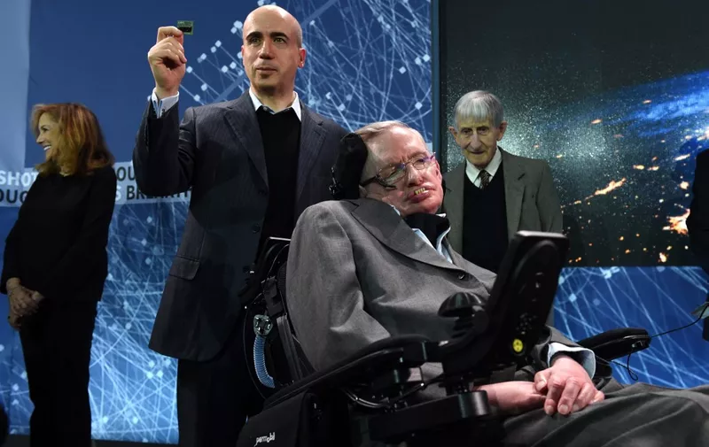 Internet investor and science philanthropist Yuri Milner holds up a StarChip with renowned cosmologist Professor Stephen Hawking during a press conference at One World Observatory April 12, 2016 in New York, to announce a new breakthrough initiative focusing on space exploration and the search for life in the universe. (Photo by TIMOTHY  A. CLARY / AFP)