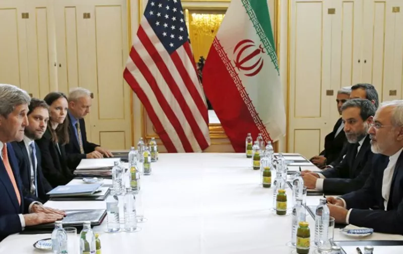 US Secretary of State John Kerry (L)  meets with Iranian Foreign Minister Javad Zarif (R) in Vienna, Austria on January 16, 2016, on what is expected to be "implementation day,"  the day the International Atomic Energy Agency (IAEA) verifies that Iran has met all conditions under the nuclear deal.  
 / AFP PHOTO / POOL / KEVIN LAMARQUE