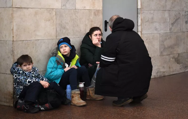 A family takes shelter in a metro station in Kyiv in the morning of February 24, 2022. Air raid sirens rang out in downtown Kyiv today as cities across Ukraine were hit with what Ukrainian officials said were Russian missile strikes and artillery. - Russian President Vladimir Putin announced a military operation in Ukraine on Thursday with explosions heard soon after across the country and its foreign minister warning a "full-scale invasion" was underway. (Photo by Daniel LEAL / AFP)
