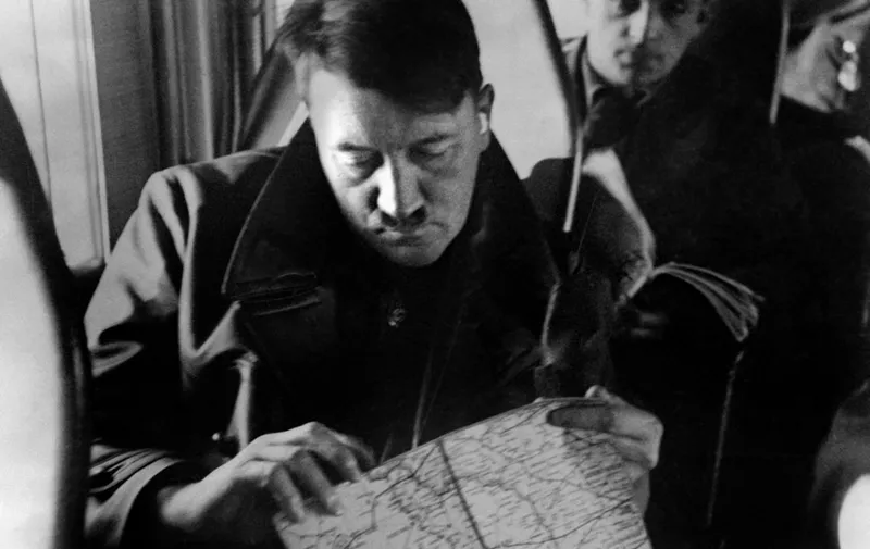 An undated picture shows German Nazi Chancellor Adolf Hitler in a plane looking at a map with Governor-general of Nazi-occupied Poland, Hans Frank in the background. AFP PHOTO / FRANCE PRESSE VOIR (Photo by FRANCE PRESSE VOIR / AFP)