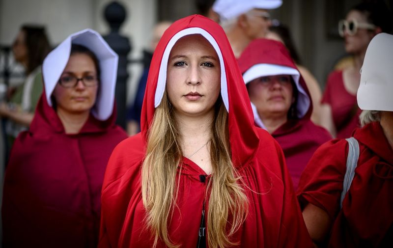 Handsmaid themed protesters stand outside Jackson Square in the French Quarter of New Orleans, Louisiana, on May 25, 2019, to protest the proposed Heartbeat Bill that will ban abortion after 6 weeks in that state scheduled for a vote on May 28. (Photo by Emily KASK / AFP)