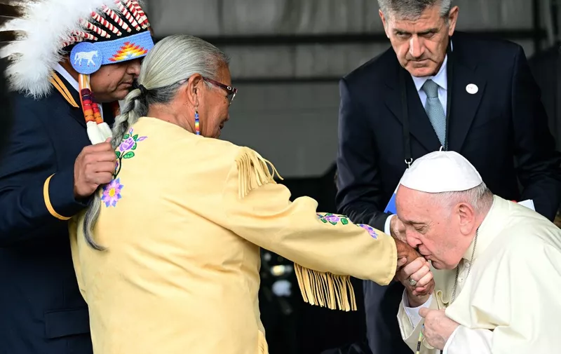 Pope Francis greets members of an indigenous tribe during his welcoming ceremony at Edmonton International Airport in Alberta, western Canada, on July 24, 2022. - Pope Francis visits Canada for a chance to personally apologize to Indigenous survivors of abuse committed over a span of decades at residential schools run by the Catholic Church. (Photo by Vincenzo PINTO / AFP)