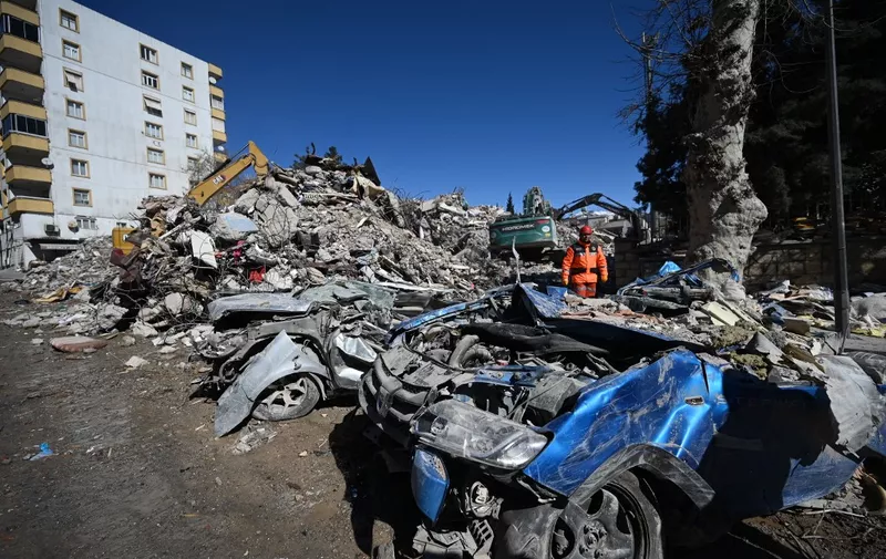 A rescuer walks past rubble near the site where Aleyna Olmez, 17, was rescued from a collapsed building, 248 hours after the 7.8-magnitude earthquake which struck parts of Turkey and Syria, in Kahramanmaras on February 16, 2023. (Photo by OZAN KOSE / AFP)