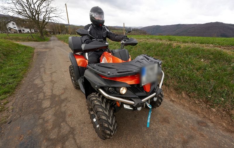 27 March 2021, Rhineland-Palatinate, Nievern: A quad rider is driving on a country road. According to accident expert Brockmann, the risk of being seriously injured or even killed in an accident is ten times higher with a quad than with a car.           (to dpa: "Where the fun stops: Of the risky pleasure with the quad") Photo: Thomas Frey/dpa - ATTENTION: The license plate of the vehicle was pixelated for legal reasons (Photo by THOMAS FREY / DPA / dpa Picture-Alliance via AFP)