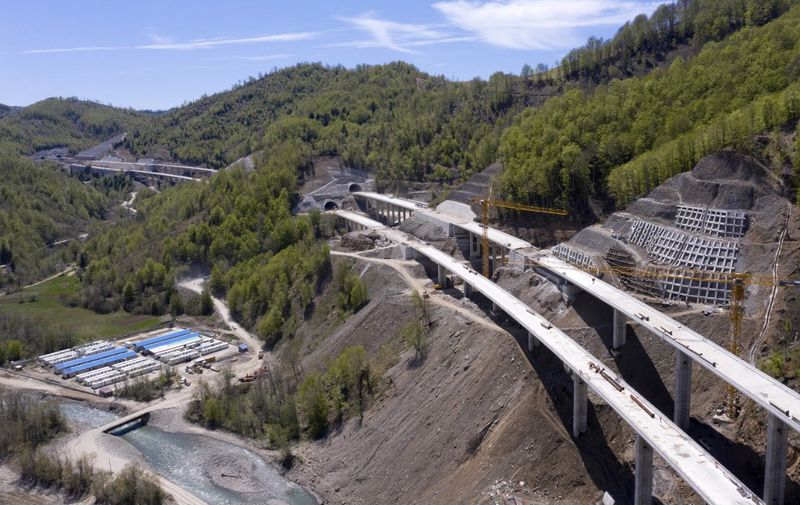 An aerial views shows a part of the new highway connecting the city of Bar on Montenegros Adriatic coast to landlocked neighbour Serbia, (Bar-Boljare highway) on May 11, 2021, near Matesevo, which is being constructed by China Road and Bridge Corporation (CRBC), the large state-owned Chinese company. - Two sleek new roads vanish into mountain tunnels high above a sleepy Montenegrin village, the unlikely endpoint of a billion-dollar project that is threatening to derail the tiny country's economy. The government has already burnt through $944 million in Chinese loans to complete the first stretch of road, just 41 kilometres (25 miles), making it among the world's most expensive pieces of tarmac. Chinese workers have spent six years carving tunnels through solid rock and raising concrete pillars above gorges and canyons, but the road in effect goes nowhere. Almost 130 kilometres still needs to be built at a likely cost of at least one billion euros ($1.2 billion). (Photo by SAVO PRELEVIC / AFP)