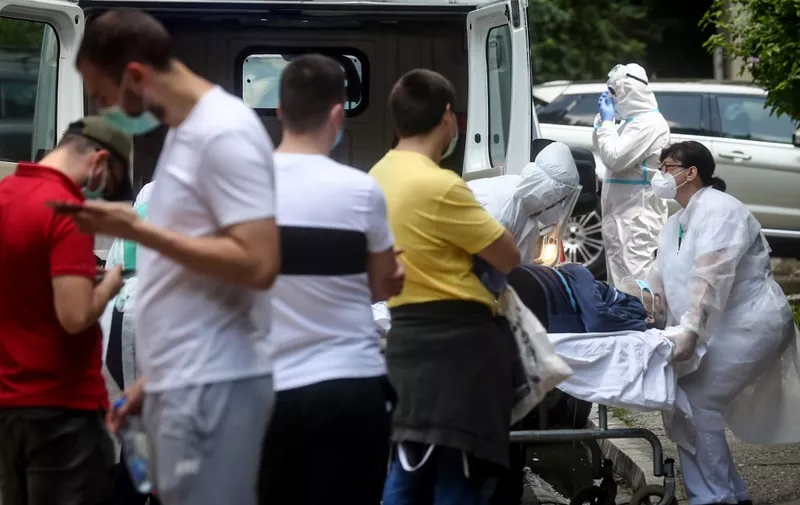Medical workers carry a patient to the Clinic for Infectious and Tropical Diseases in Belgrade on June 24, 2020, as the number of coronavirus (COVID-19) cases grow again in Serbia. - Serbia officially confirmed on June 24, 2020, a total of 13,235 cases of the coronavirus (143 more than Tuesday). Out of that number a total of 263 have died. (Photo by Oliver BUNIC / AFP)